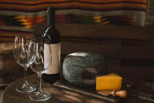 Close-up shot of cheese and wine on rustic wooden table — Stock Photo