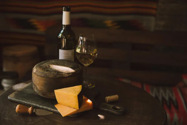 Delicioso queijo com vinho branco na mesa de madeira rústica — Fotografia de Stock