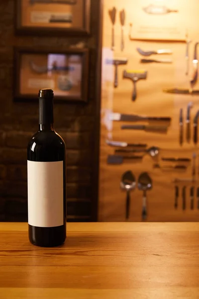 Close-up shot of bottle of red wine on wooden table — Stock Photo