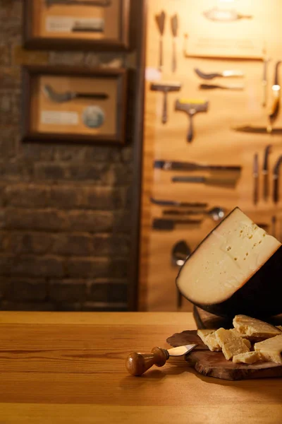 Primo piano di formaggio a fette con coltello sul tagliere di legno — Foto stock