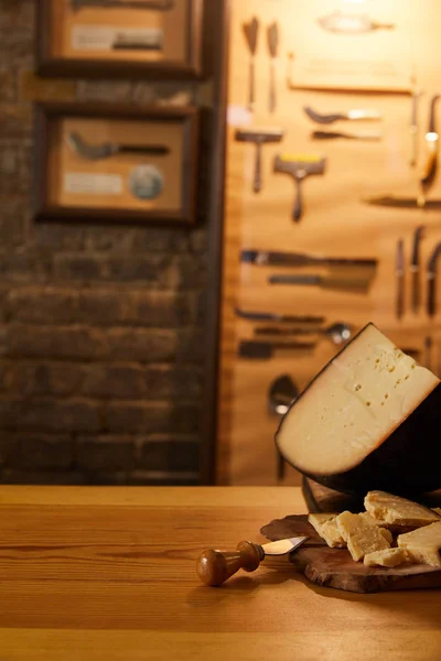 Close-up shot of sliced cheese with knife on wooden cutting board — Stock Photo