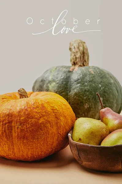 Primer plano de la cosecha otoñal con calabazas y peras deliciosas maduras en la mesa con letras de AMOR OCTUBRE - foto de stock