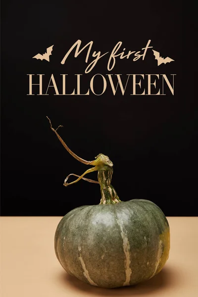 One green pumpkin on table with bats and 