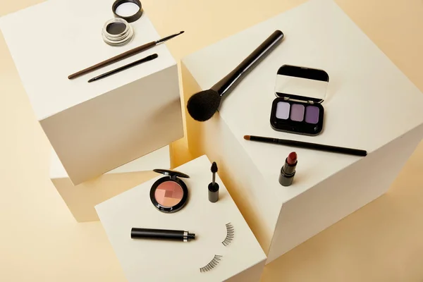 Blick auf verschiedene Make-up Accessoires auf beigen Würfeln — Stockfoto