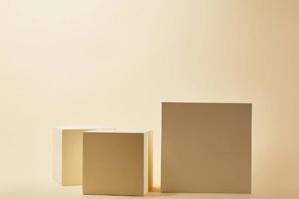Natura morta di cubi in varie dimensioni su superficie beige — Foto stock