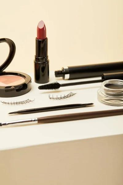 Close-up shot of various makeup accessories on beige — Stock Photo