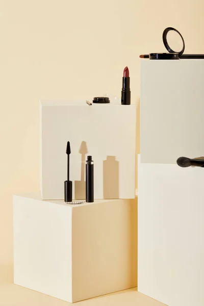 Various makeup supplies lying on beige cubes — Stock Photo