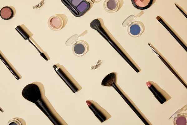 Vista superior de la composición de diferentes cosméticos que se encuentran en la superficie beige - foto de stock