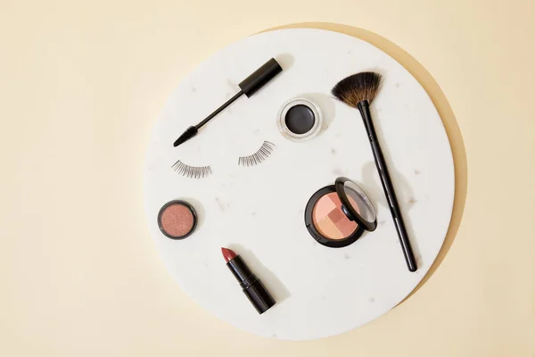 Top view of various cosmetics lying on round plate — Stock Photo