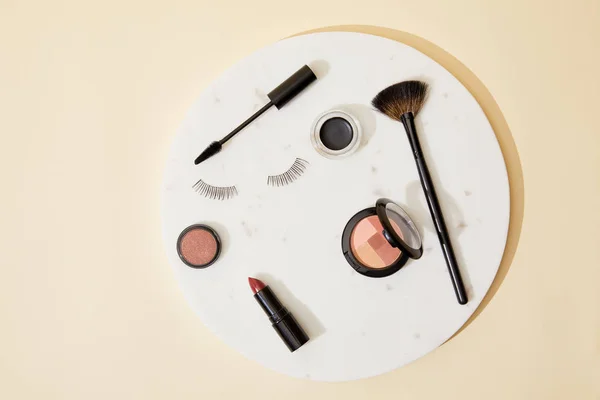 Vue de dessus de divers cosmétiques couchés sur la plaque ronde — Photo de stock