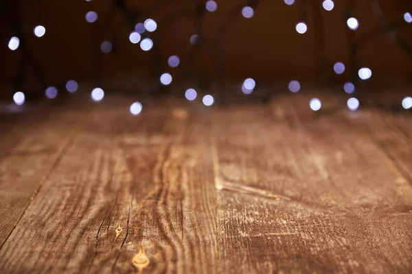 Close up view of wooden tabletop and defocused bokeh lights backdrop — Stock Photo