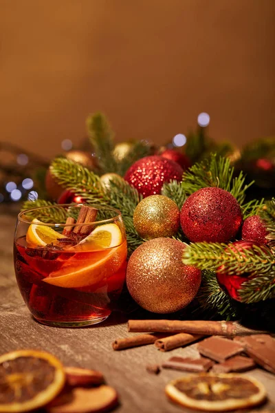 Vista da vicino della bevanda di vin brulè in vetro e pino con giocattoli di Natale sulla superficie di legno — Foto stock