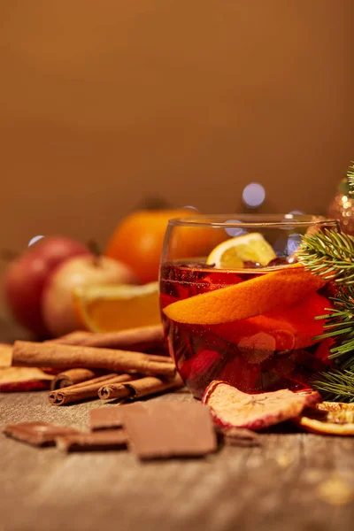 Vue rapprochée de savoureux vin chaud boisson, chocolat et branche de pin sur la surface en bois — Photo de stock