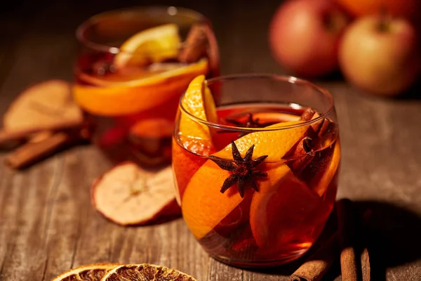 Vista de cerca de deliciosas bebidas de vino caliente con especias y especias en la mesa de madera - foto de stock