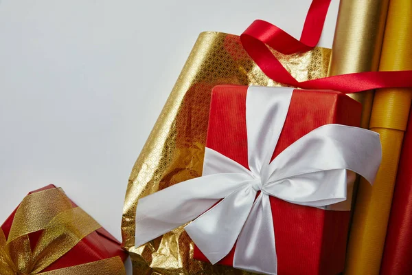 Acostado plano con regalos de Navidad envueltos, cintas y papeles de embalaje sobre fondo blanco - foto de stock