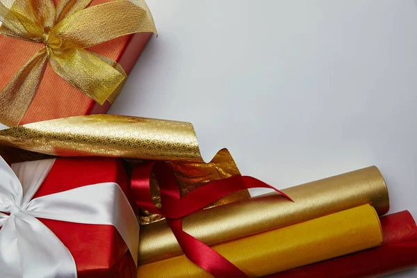 Vue du dessus des cadeaux avec des rubans et des papiers d'emballage lumineux sur fond blanc — Photo de stock