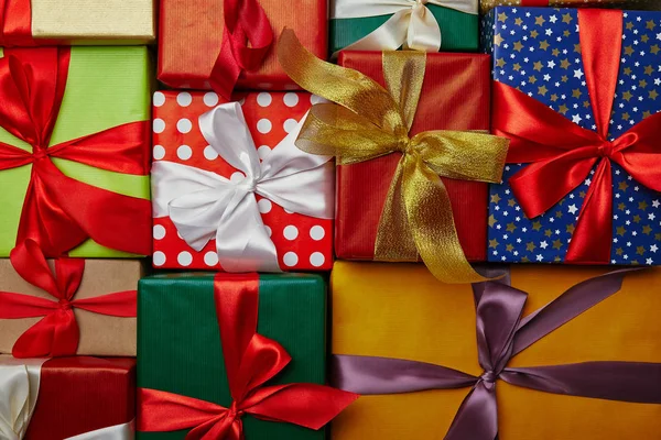 Posa piatta con regali di Capodanno avvolti in diverse carte da imballaggio con nastri su superficie di legno — Foto stock