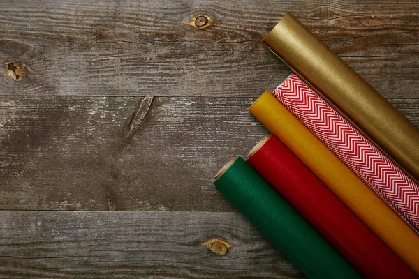 Вид зверху розставлені обгорткові папери різних кольорів на дерев'яному фоні — стокове фото