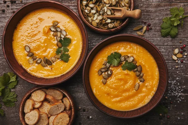 Top view of tasty healthy pumpkin soup with rusks on wooden table — Stock Photo