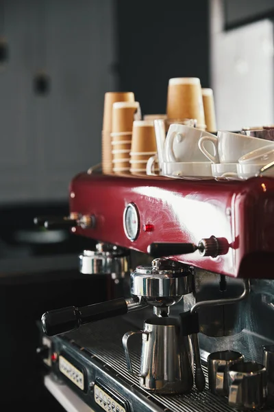 Профессиональная кофеварка с кружками и бумажными чашками в кофейне — стоковое фото
