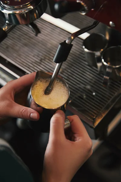 Обрезанный снимок баристы, готовящей капучино в кофеварке — стоковое фото