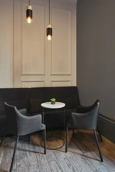 Interior de la cafetería moderna con muebles cómodos y bombillas iluminadas - foto de stock