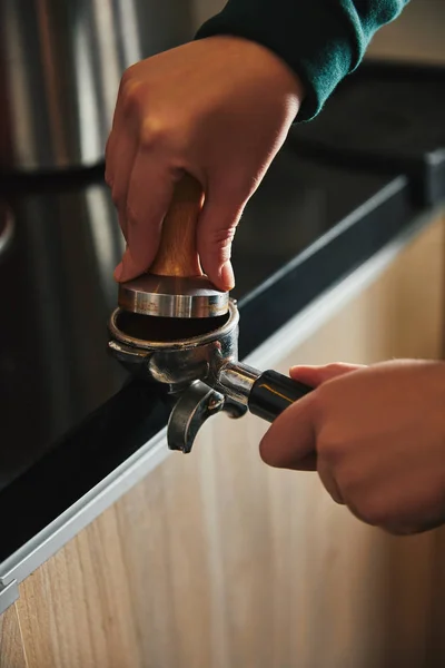 Primer plano vista parcial de barista preparando espresso en cafetera - foto de stock