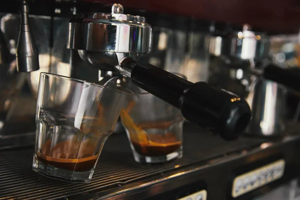 Primer plano de la cafetera que prepara el espresso en dos tazas - foto de stock