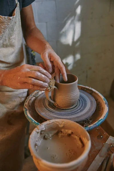 Imagen recortada de alfarero trabajando en la rueda de cerámica en el taller — Stock Photo