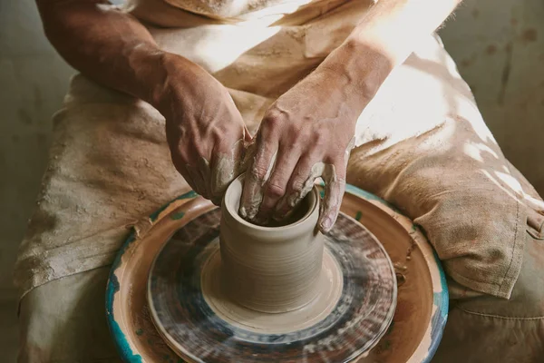 Close up view of male potter hands working on pottery wheel at workshop — Stock Photo