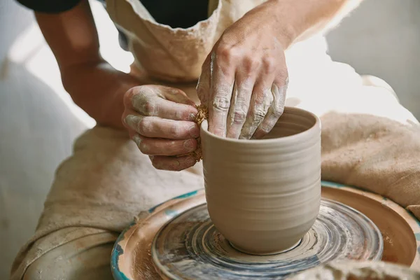 Abgeschnittenes Bild eines männlichen Handwerkers, der im Töpferatelier an der Töpferscheibe arbeitet — Stockfoto