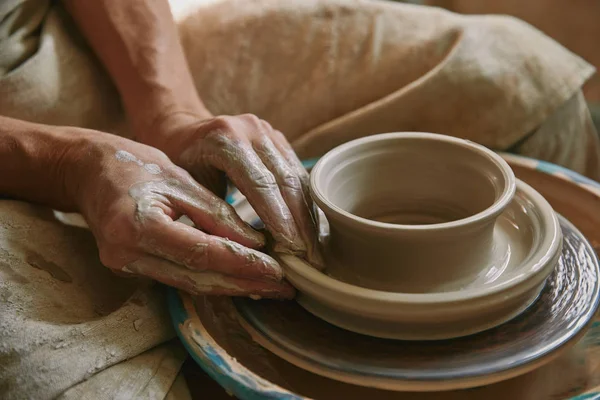 Close up view of professional potter working on pottery wheel at workshop — Stock Photo