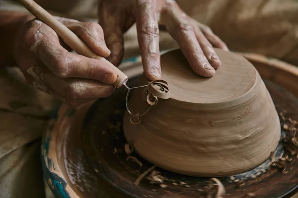 Vue rapprochée du potier professionnel décorant pot d'argile à l'atelier — Photo de stock