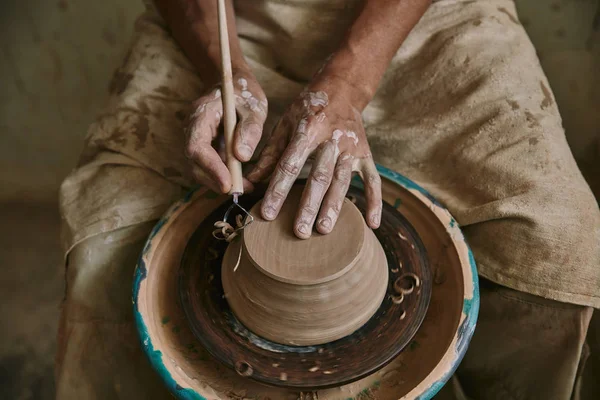 Partial view of professional potter decorating clay pot at workshop — Stock Photo