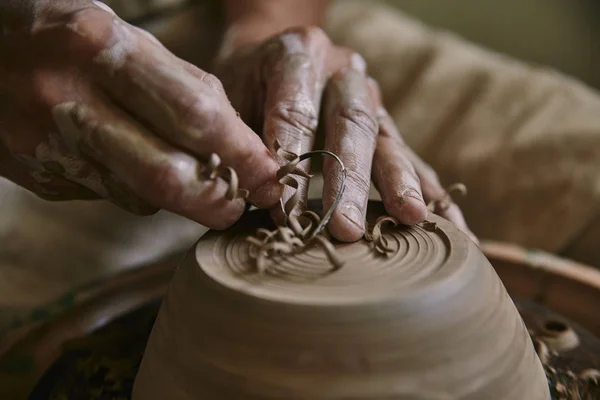 Selective focus of professional potter decorating clay pot at workshop — Stock Photo