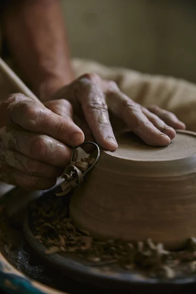 Крупный план профессионального гончара, украшающего глиняный горшок в мастерской — стоковое фото