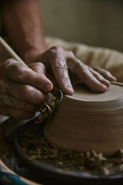 Close up view of professional potter decorating clay pot at workshop — Stock Photo