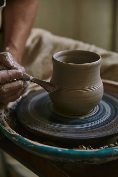 Vue rapprochée du potier professionnel décorant pot d'argile à l'atelier — Photo de stock