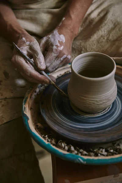 Partial view of professional potter decorating clay pot at workshop — Stock Photo