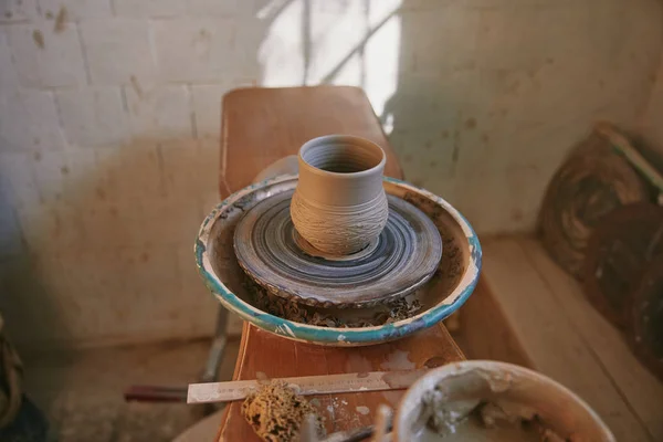 Selective focus of clay pot on pottery wheel at workshop — Stock Photo