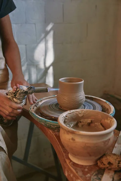 Vue partielle du potier mâle dans le tablier de cuisson pot d'argile au studio de poterie — Photo de stock