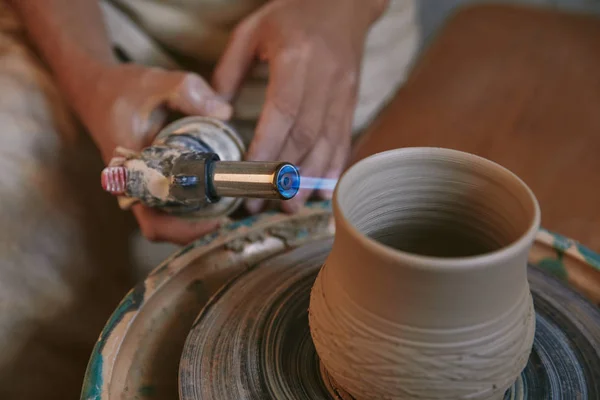 Selective focus of male potter firing clay pot at pottery studio — Stock Photo