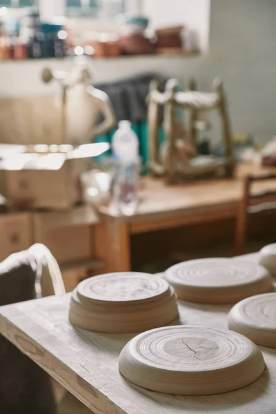 Selective focus of plates at table in pottery studio — Stock Photo