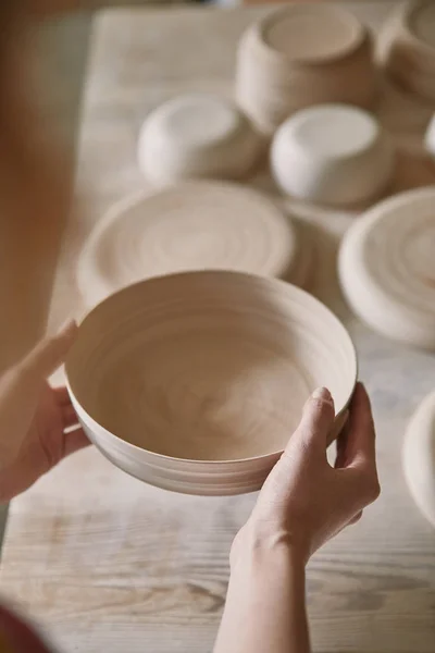 Messa a fuoco selettiva della donna che tiene piatto di ceramica in studio di ceramica — Foto stock