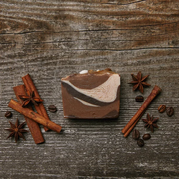 Vue du dessus du savon fait à la main avec des épices sur plateau en bois rustique — Photo de stock