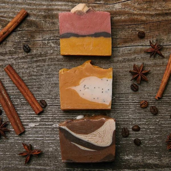 Top view of various handmade soap pieces with spices on rustic wooden tabletop — Stock Photo
