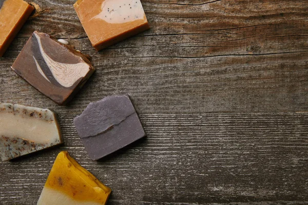 Top view of various handmade soap pieces on rustic wooden tabletop — Stock Photo