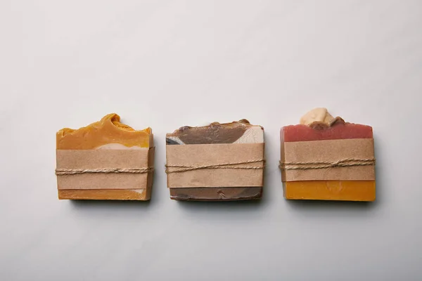 Vista dall'alto di fila di vari pezzi di sapone aromatico sulla superficie di marmo bianco — Foto stock