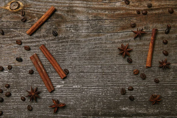 Top view of cinnamon sticks with anise and coffee beans on rustic wooden table — Stock Photo