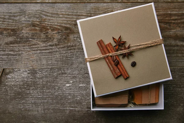 Vue du dessus des morceaux de savon faits à la main dans une boîte décorée sur une table en bois rustique — Photo de stock